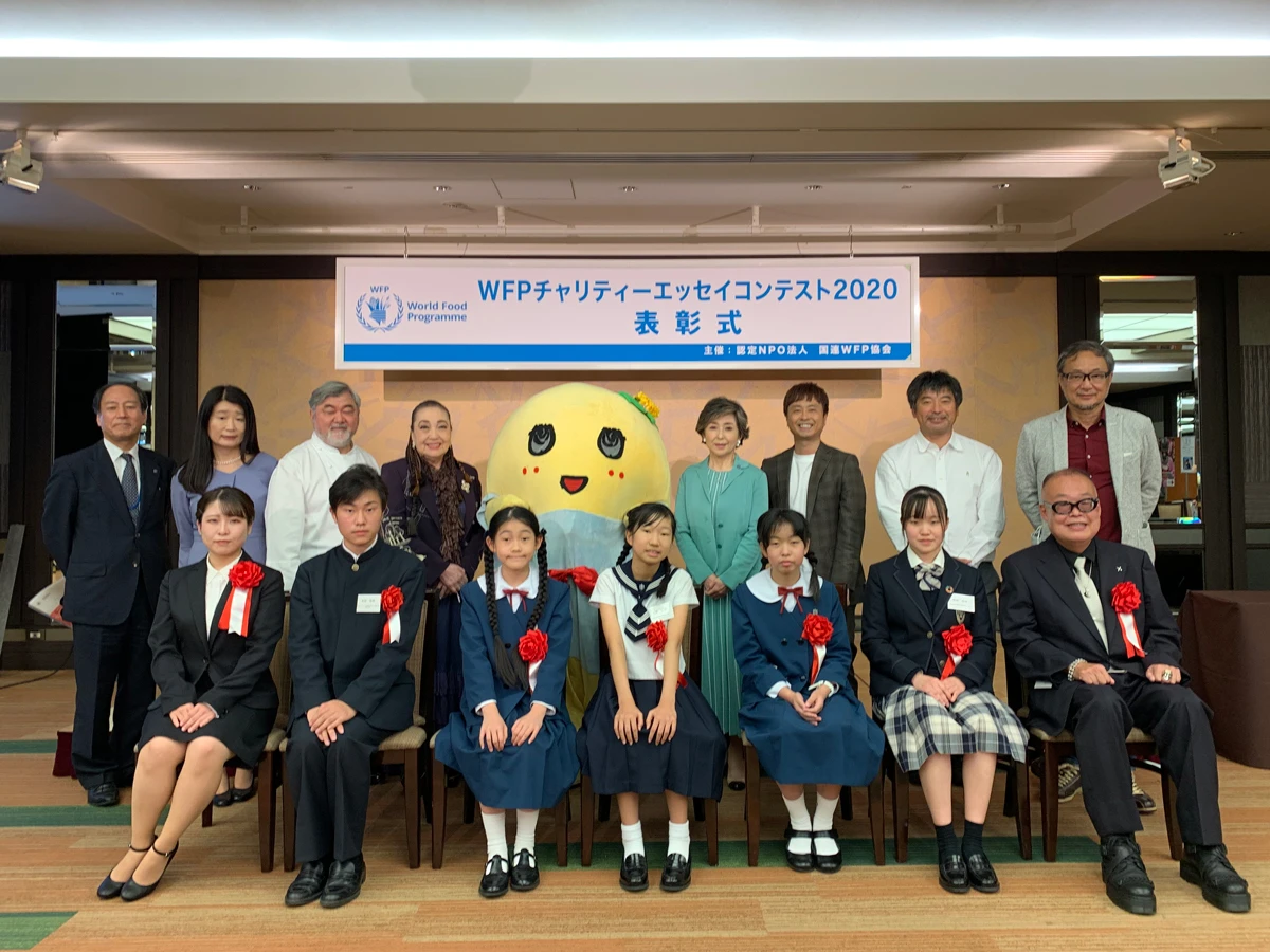 『おひさまミートソース』  神奈川県　相蘇 仁那（あいそ にな）     「ひどいことを言ってしまった。」わかっているけれど、「ごめんなさい」の言葉は心のとげとげにつっかかって出てこない。 母が入院した一週間と少しの間、父と二人だけで生活した。食事とお弁当は父が作ってくれたけれど、からあげは固いし、卵焼きは甘すぎる。食べる度に母がいないと実感してイライラするのだ。晩ご飯は必ずからあげと卵焼きで、その残りが私のお弁当になる。 ある日、私がお弁当をほとんど残して帰ると、父は具合が悪いのかと聞いてきた。私は食欲がなかったと答えて、晩ご飯も残した。それでも父はしつこくて、少しでもいいから食べなさいとうるさかった。 「うるさいな！だってまずいんだもん。それにいつもいつも同じだし！」 一気に言ってしまってから後悔した。怒られるとかくごしたけれど、父は 「ごめんな。」 と言ったきり何も言わなかった。 次の日学校にいる間ずっと、夕べのことを後悔しながら過ごした。帰宅して重たい気持ちで玄関のドアを開けると、ふわっと良いにおいがして、笑顔の父が立っていた。 「今日はミートソースだぞ。」 机の上には、丸くて真っ赤でお日さまみたいなミートソースが二つ並んでいた。一口食べたら、甘ずっぱくておいしかった。おいしいのに涙があふれて止まらなかった。一緒に泣き出しそうな顔をしている父に、 「おいしいよ。」 と泣き笑いで言うと 「よかったー！お母さんに電話して教えてもらって、朝からがんばったんだぞ。」 と得意気に言った。私は泣きながら全部食べて、言えなかった「ごめんなさい」も言えた。 あれからずっと、父の得意料理も私の元気ごはんも、あのおひさまみたいなミートソース。それを食べる度に私は、甘ずっぱくて温かい気持ちになるのだ。